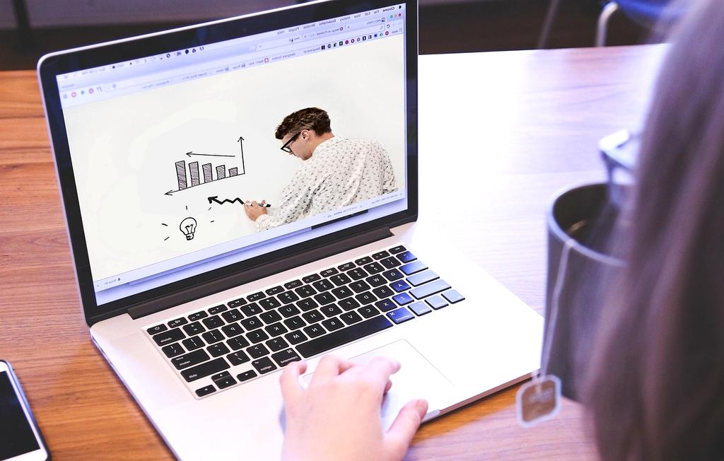 Open laptop displaying online courses interface in a colorful workspace